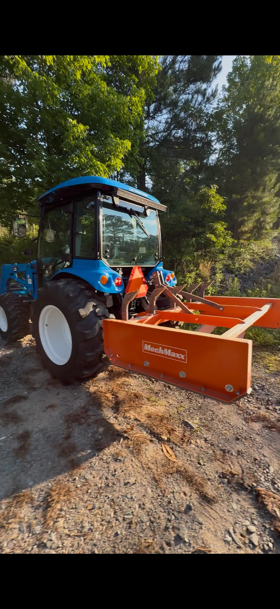 LS tractor performing driveway grading